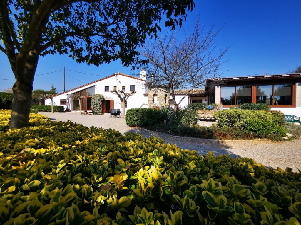 Vue sur le jardin et la façade de la maison de vacances Can Micos, parfaite pour un union champêtre dans un cadre naturel.