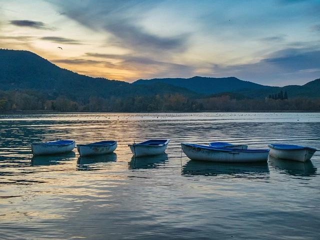 Barcas de remo en el Lago de Banyoles al atardecer, una actividad recomendada sobre qué hacer en Banyoles cerca de nuestra casa rural. Haz turismo rural de calidad